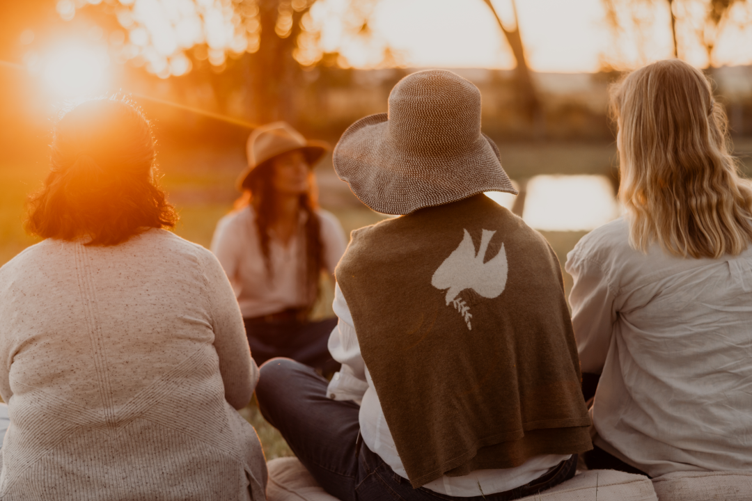 Group of women sitting outdoors during sunset